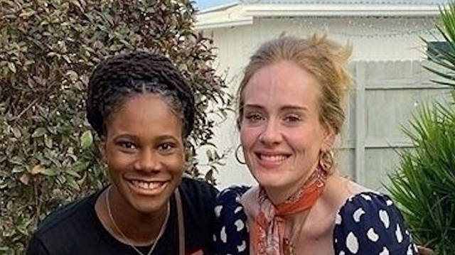 Adele poses for a photo with a fan while on Caribbean holiday