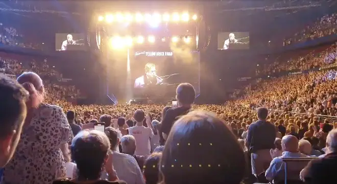 The audience stand from their seats to applaud the singer following the announcement of his donation.