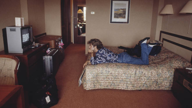 George Michael lies on a bed watching television in a hotel room in Sydney, Australia during the pop duo's 1985 world tour in January 1985.