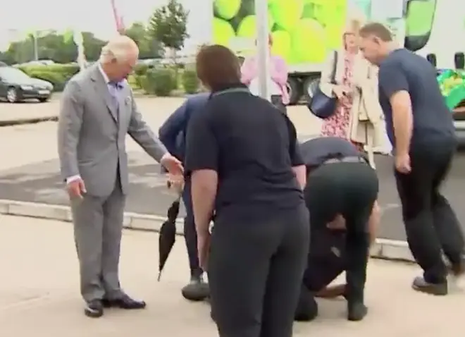 Members of staff rushed to help the man as Prince Charles waited to see if he was ok