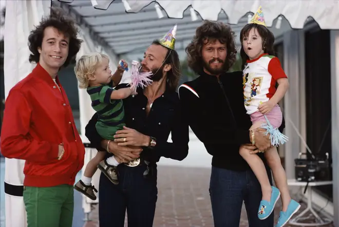 Bee Gees (left to right) Robin, Maurice and Barry Gibb with their children in Miami, Florida, March 1978.
