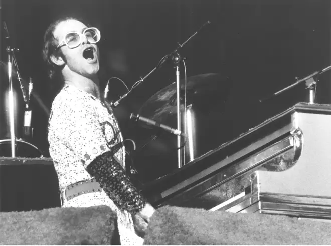 Elton John and a "gang" of friends including Bernie Taupin, manager Ray Williams, producer Steve Brown, roadie Bob Stacey flew to Los Angeles for Elton to make his debut at the famous Troubadour club. Pictured in 1974
