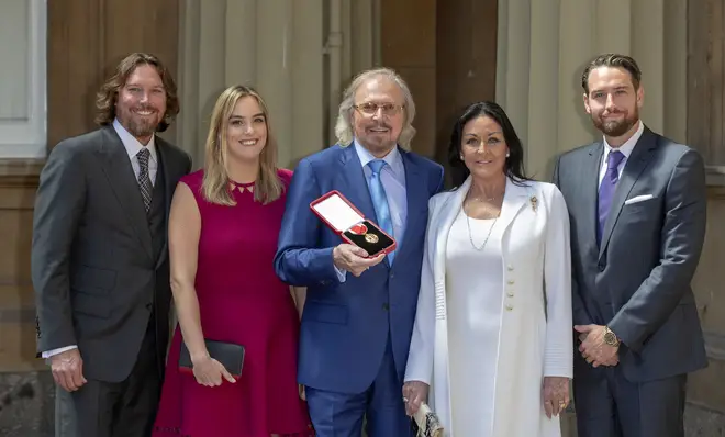 Barry Gibb, with his wife, Linda and children, Michael (right), Alexandra and Ashley (left) at Buckingham Palace after the Bee Gee was knighted by the Prince of Wales on June 26, 2018