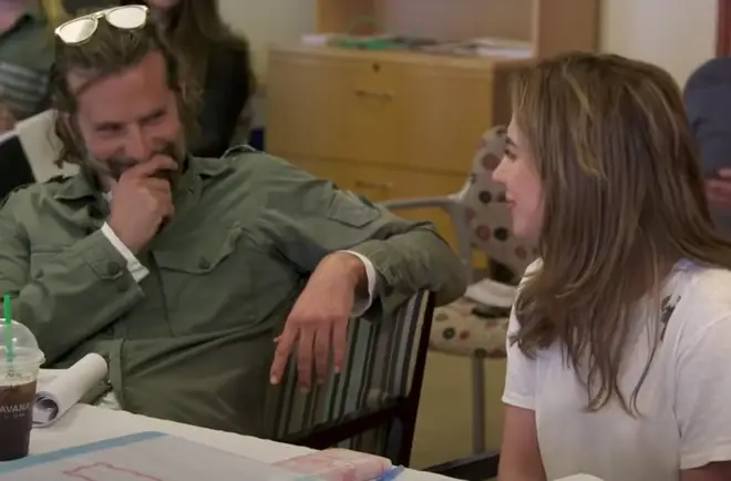 Bradley Cooper sits by her side watching her avidly as she sings and is the first to congratulate Lady Gaga when she finished singing with a smile and a reassuring squeeze of her shoulder.