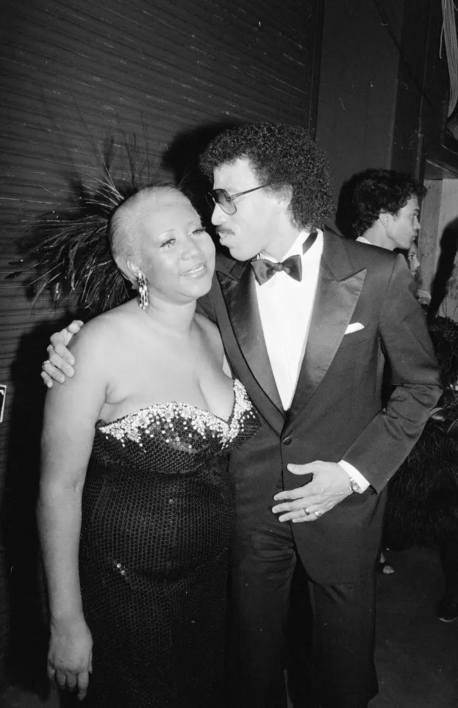 Lionel Richie kisses Aretha Franklin on the cheek at the 1985 American Music Awards.