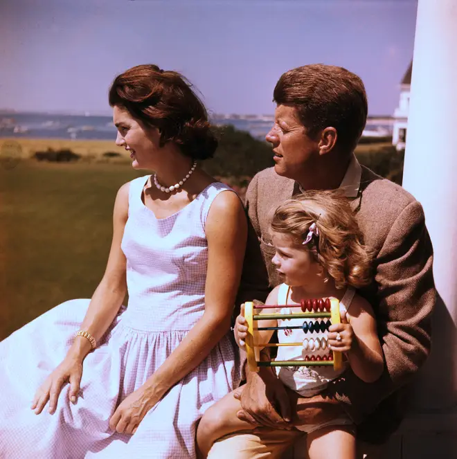 John F. Kennedy relaxes with his wife Jacqueline and daughter Caroline