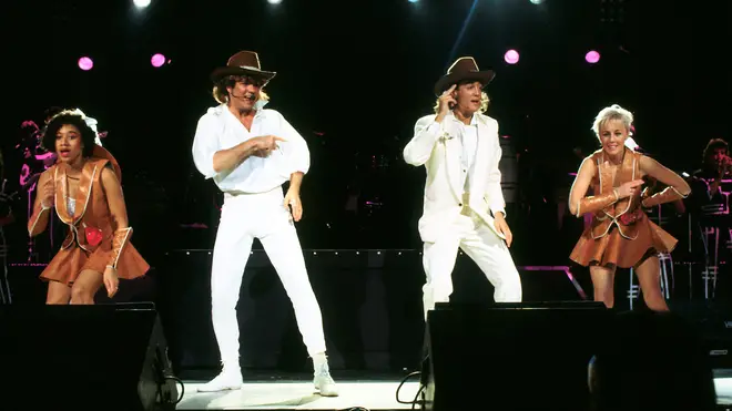 Wham!'s Pepsi, George, Andrew, and Shirlie performing on stage in 1985. (Photo by Michael Putland/Getty Images)
