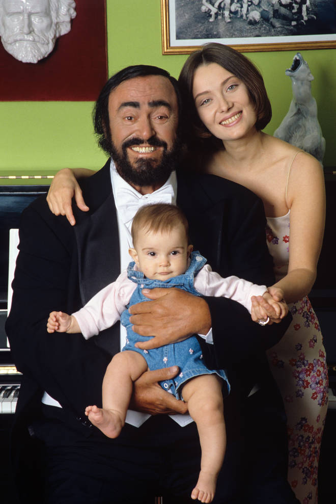Luciano Pavarotti poses holding his daughter Alice, with his wife Nicoletta Mantovani