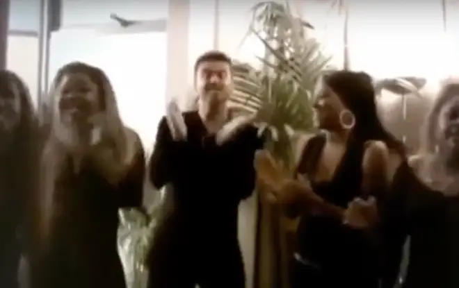 George Michael can be seen in teh clip laughing and clapping with his four female vocalists.