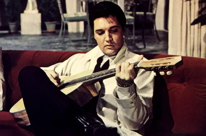Elvis Presley pictured playing his acoustic guitar