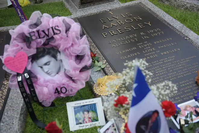Tributes and momentoes are seen next to the grave marker for Elvis Presley in the Meditation Garden where he is buried alongside his parents and grandmother at his Graceland mansion in Memphis, Tennessee.