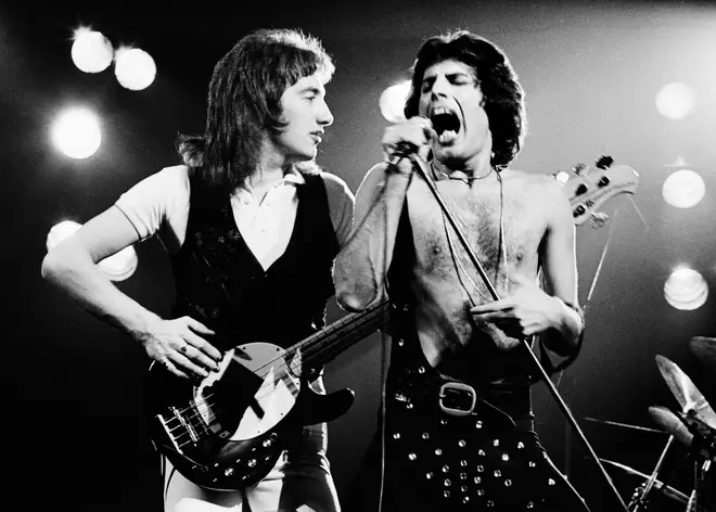 Speaking to RockFM in Spain, Brian May opened up about the likelihood of John Deacon returning to Queen and his and Roger Taylor's efforts to lure him back. (Pictured L to R: John Deacon and Freddie Mercury in 1977)