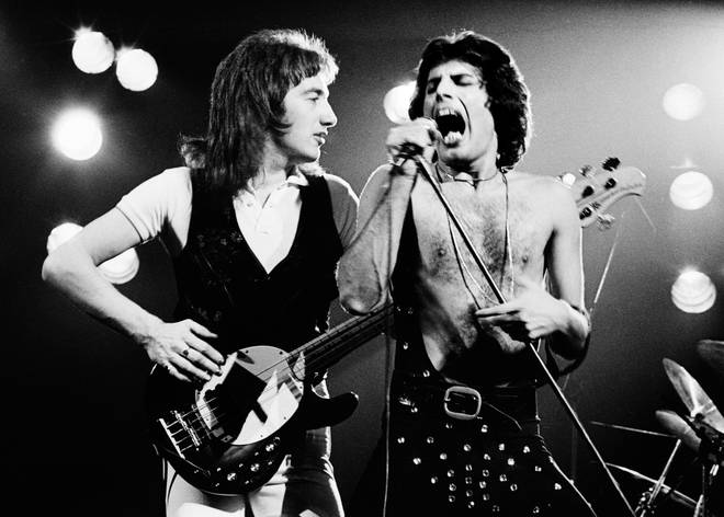 Speaking to RockFM in Spain, Brian May opened up about the likelihood of John Deacon returning to Queen and his and Roger Taylor's efforts to lure him back. (Pictured L to R: John Deacon and Freddie Mercury in 1977)