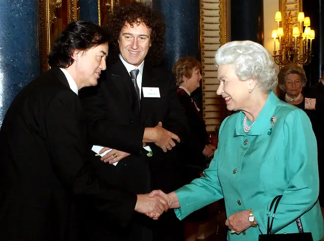Brain May pictured meeting the Queen at Buckingham Palace in 2005.