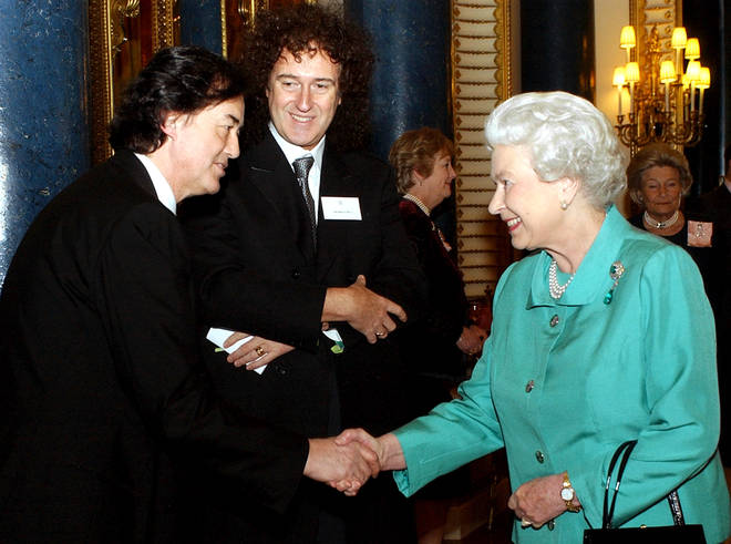 Brain May pictured meeting the Queen at Buckingham Palace in 2005.