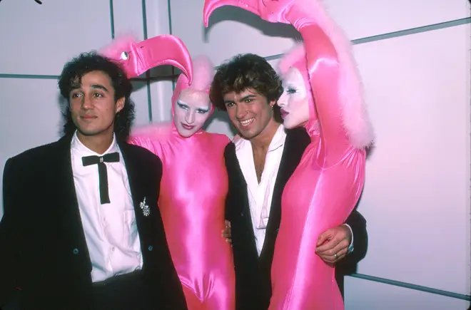 Andrew Ridgeley and George Michael of pop group Wham! with pink flamingo dancers