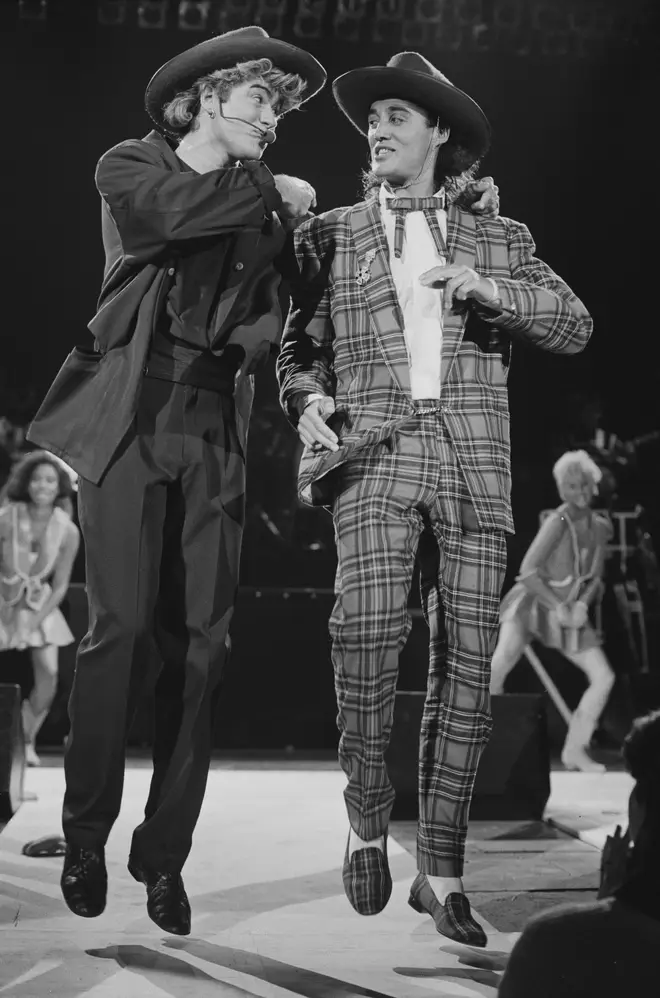 George Michael and Andrew Ridgeley of Wham! performing during the pop duo's 1985 world tour, January 1985. In the background are backing singers Pepsi and Shirley