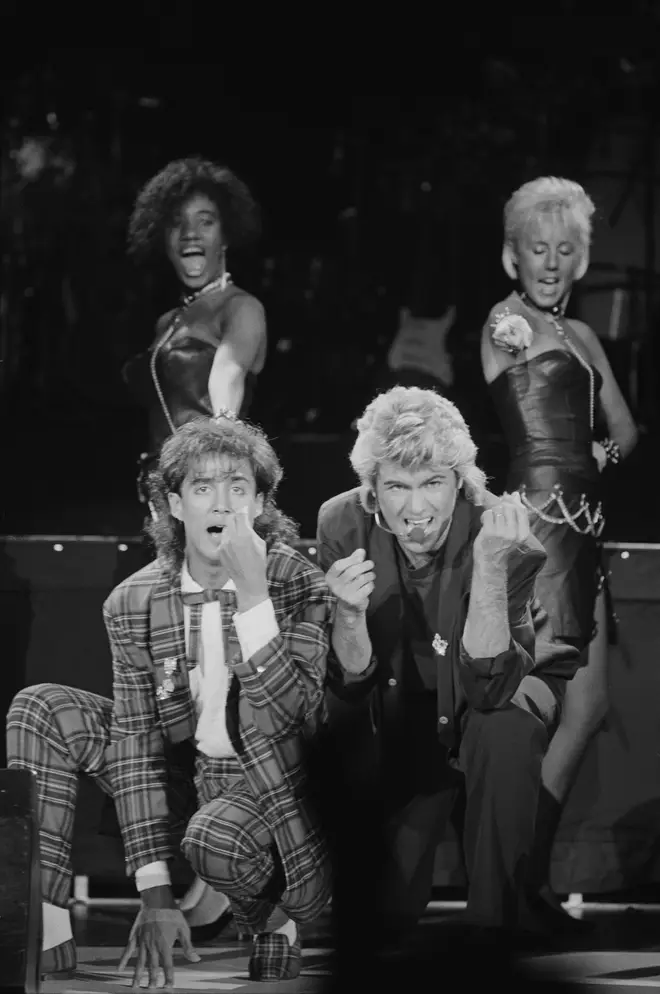 Andrew Ridgeley and George Michael of Wham! performing during the pop duo's 1985 world tour, January 1985. In the background are backing singers Pepsi and Shirley