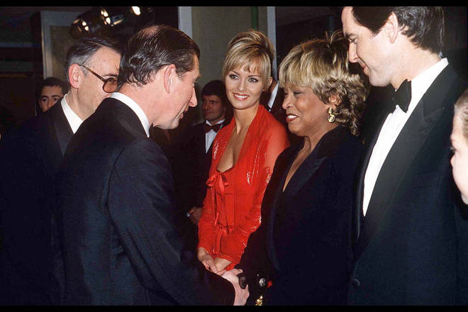 Tina Turner greeting King Charles III next to Pierce Brosnan at the 1995 film premiere for Goldeneye. (Photo by © Pool Photograph/Corbis/Corbis via Getty Images)