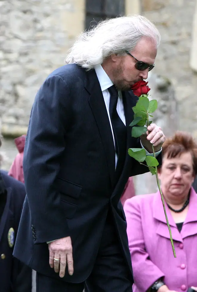 Barry Gibb kisses a rose just before placing it on his brother's coffin during Robin's funeral. (Photo by Danny Martindale/FilmMagic)