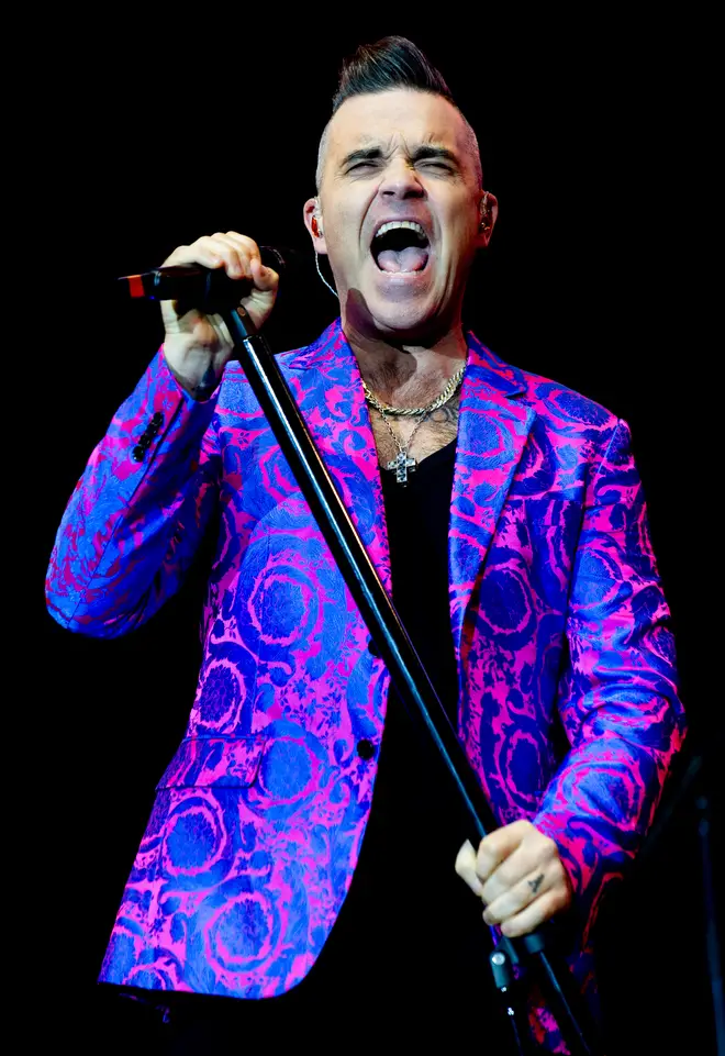 Robbie Williams revealed to fans he is suffering from long Covid after he stopped his band from playing so he could have a rest mid-show.