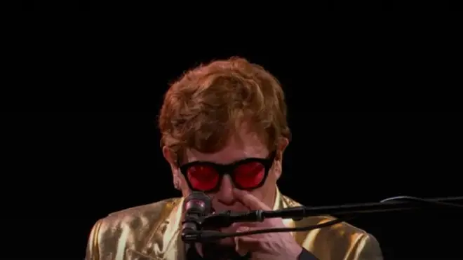 Sir Elton subtly wiped away his tears as he finished his tribute to George.