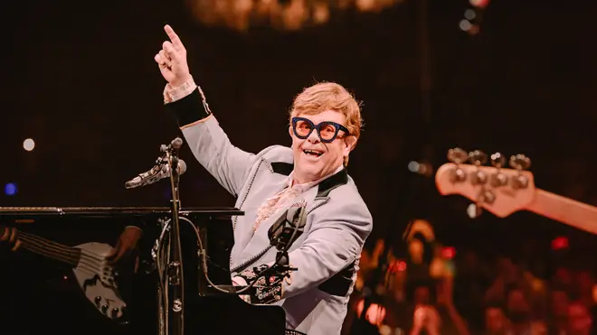 Elton John salutes his band on stage
