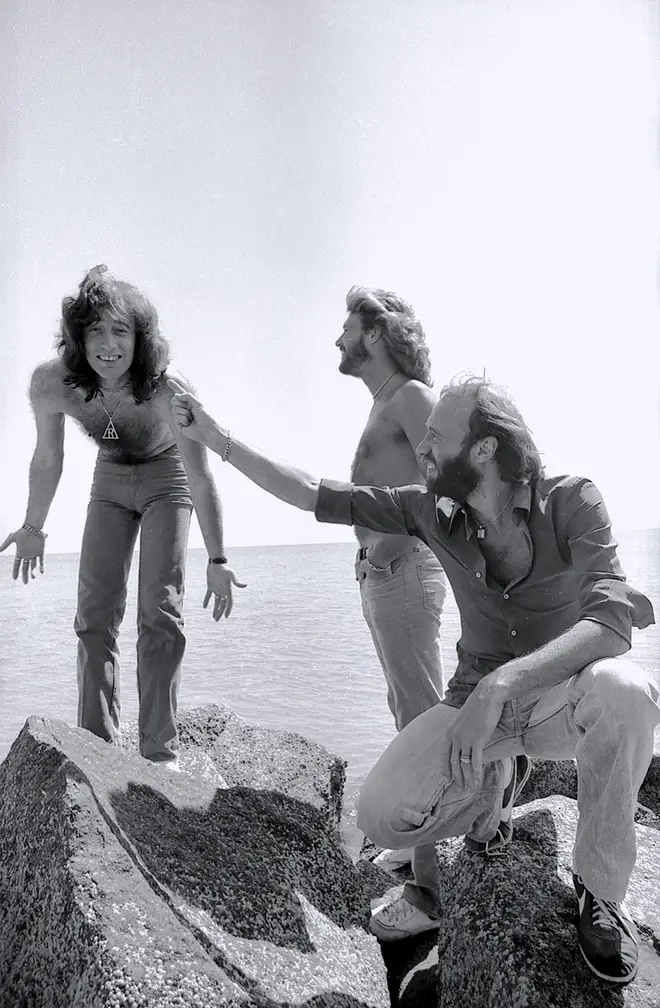 Barry, Maurice and Robin laughing together on rocks overlooking the ocean in Florida in 1979. (Photo by Bonnie Schiffman/Getty Images)
