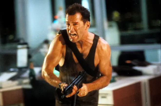 Bruce Willis running with automatic weapon in a scene from the film 'Die Hard', 1988.