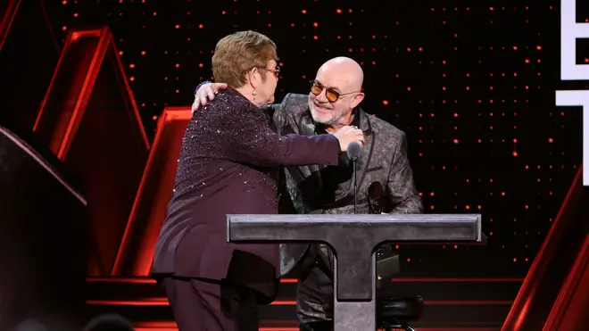 Elton and Bernie share an embrace