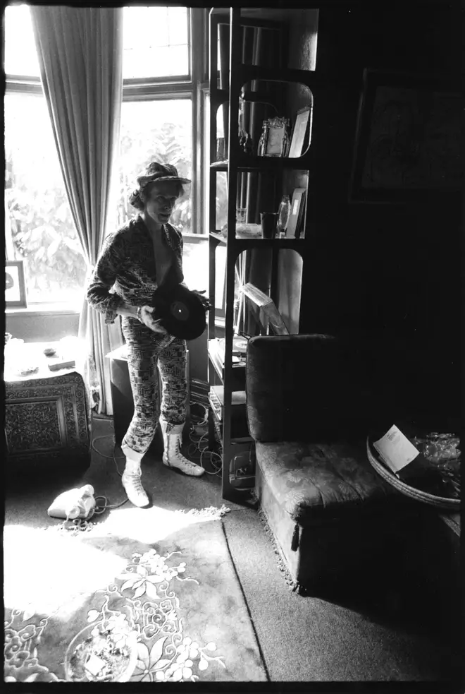 David Bowie holding an LP at his ground floor flat at Haddon Hall, where he has been redecorating the ceiling in silver paint, Beckenham, Kent on 24th April 1972.