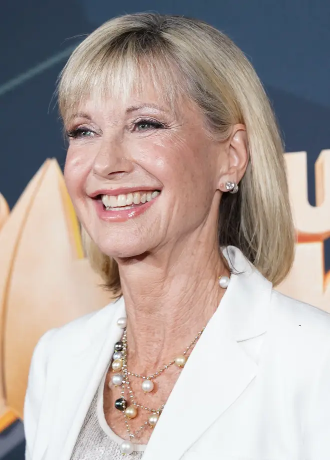 Olivia Newton-John smiles for photographers on the red carpet