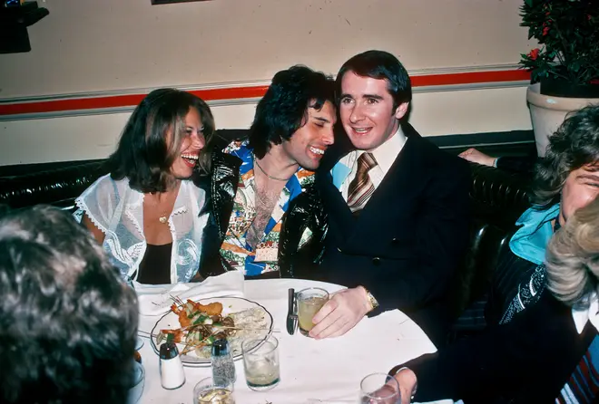 Freddie at a Queen after-party with the band's manager John Reid, March 1977.