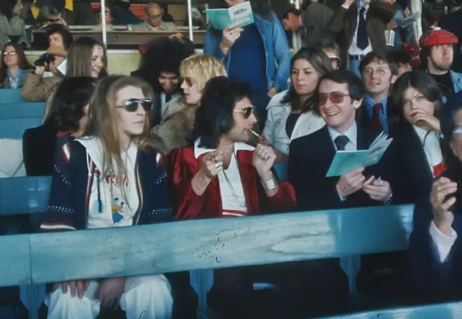 Queen at Kempton Park Racecourse in Surrey, to promote their album 'A Day at the Races', September 23rd 1976. Freddie is accompanied by Mary Austin and manager John Reid.