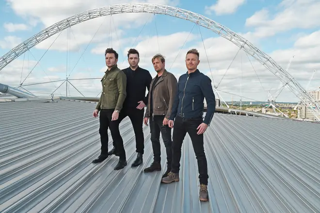 Westlife posing on the roof of Wembley Stadium after speaking to Smooth Radio